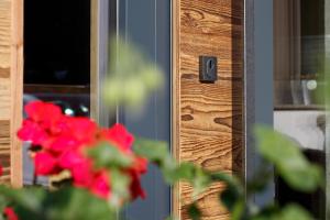 a close up of a wooden door with red flowers at GB Gondelblick in Sölden