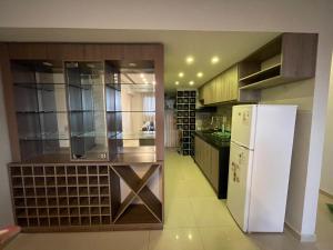 a kitchen with a white refrigerator and a counter at Departamento a 100 metros de la playa in Encarnación