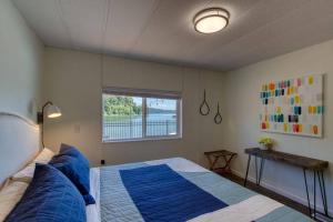 um quarto com uma cama com almofadas azuis e uma janela em Serene & Luxury Retreat, Waterfront, Hot tub, Clamming em Lilliwaup