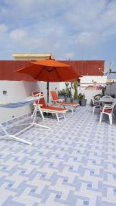 a patio with chairs and an umbrella on a roof at Perle d'Azur F2 in Saidia 