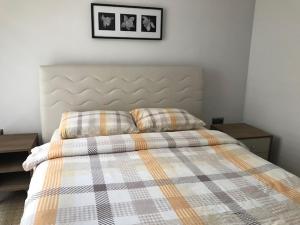 a bed with a plaid blanket and two pillows on it at Güzel Yalı Evleri Residence &Apart Hotel in Atakum