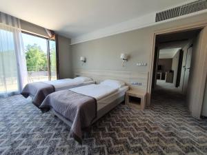 A bed or beds in a room at Kolumna Park Hotel