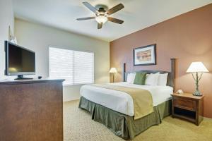 a bedroom with a bed and a flat screen tv at Raintree at Phoenix South Mountain Preserve in Phoenix