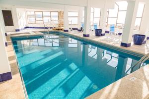 a swimming pool with blue water in a building at Hotel Club S'Illot in S'Illot