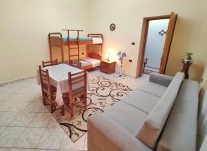 a living room with a couch and a table and a bed at Artur's Apartment in Gjirokastër