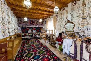 a room with a rug on the floor and a room with a store at Pensiunea Casa Traditiilor in Ieud