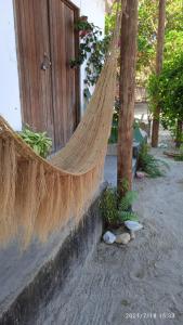 a hammock in front of a house with trees at Casa Liria Gael - Kite Is Surf School in Jericoacoara