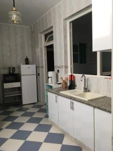 a kitchen with white appliances and a checkered floor at Perle d'Azur F3 in Saidia 