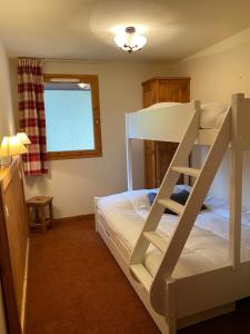 琴山朗勒堡的住宿－Les Alpages de VAL CENIS 4/5P，一间卧室配有带梯子的双层床