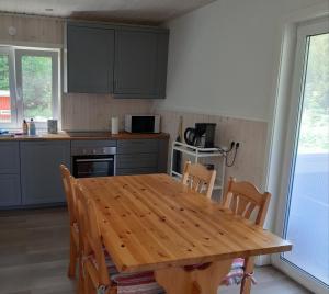 a kitchen with a wooden table and some chairs at Charming holiday home Villa Berika in Ekshärad