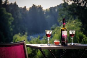 a bottle of wine and two glasses on a table at Kuća za odmor, Ferienhaus, Holiday home RUGAŠ in Orahovica