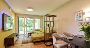 a living room with a table and chairs and a couch at Erasmus Lodge - Ferienwohnungen zum Wohlfühlen in Trassem