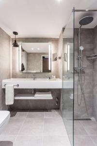
a bathroom with a shower, sink, and tub at Radisson Blu Conference Hotel, Düsseldorf in Düsseldorf
