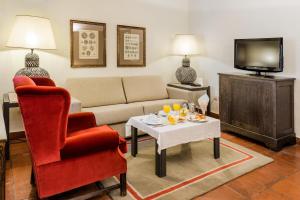 a living room with a couch and a table and a tv at Parador de Oropesa in Oropesa