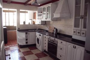 uma cozinha com armários brancos, um lavatório e uma máquina de lavar louça em Reducto's Rooms em Arrecife