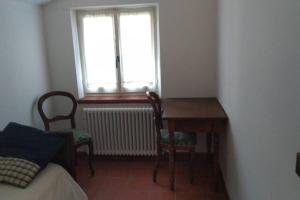 1 dormitorio con mesa, sillas y ventana en Borgo Scorza 2, en Pietramogolana
