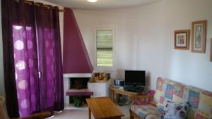 a living room with purple curtains and a couch at PRECIOSO APARTAMENTO AL LADO DE BONITA CALA in Ciutadella