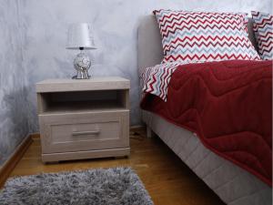 a bedroom with a bed and a night stand with a lamp at Apartment Mona in Podgorica