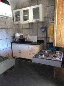 a kitchen with a stove top and white cabinets at Chalé Triunfo in Triunfo