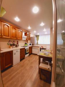 a large kitchen with wooden cabinets and white appliances at Sun City apartment 1 in Sochi