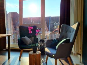 2 Stühle in einem Zimmer mit Fenster in der Unterkunft Hotel Luise Mannheim - by SuperFly Hotels in Mannheim