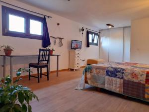 1 dormitorio con 1 cama, 1 silla y TV en Oasis Sierra en Venturada