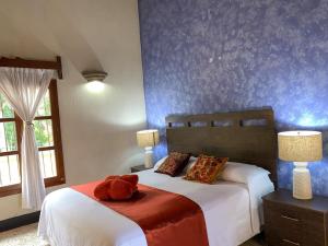 ein Schlafzimmer mit einem Bett mit einem ausgestopften Tier darauf in der Unterkunft Hotel Posada San Miguel in Antigua Guatemala