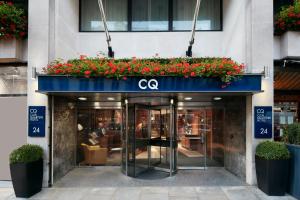 un front de magasin avec des fleurs rouges sur un auvent bleu dans l'établissement Club Quarters Hotel St Paul's, London, à Londres