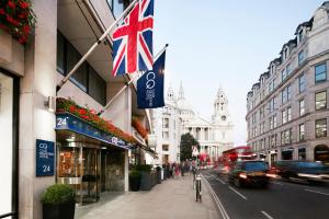 Club Quarters Hotel St Paul's, London في لندن: شارع فيه علم بريطاني معلق من مبنى