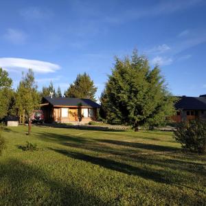 a house in the middle of a grassy yard at Masia del Valle in Trevelín