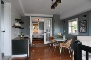eine Küche und ein Wohnzimmer mit einem Tisch und Stühlen in der Unterkunft Les Chambres Roses in West Kelowna
