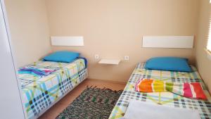 a small room with two beds and a rug at GökMavi Pansiyon in Bodrum City