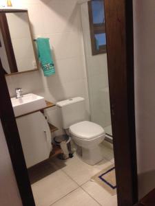 een badkamer met een wit toilet en een wastafel bij Flat Deluxe Gramado in Gramado