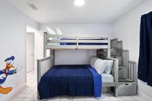 a bedroom with a bunk bed with a blue bedspread at Cozy Home Minutes Away From Disney in Kissimmee
