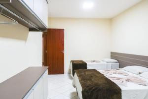 a hotel room with two beds and a kitchen at Ypê Flats e Containers in Bonito