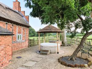 a garden with a gazebo and a tree at The Shooting Folly in Cheswardine