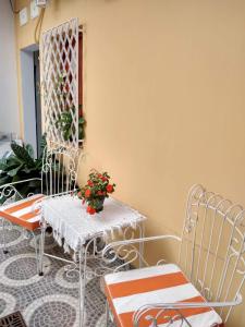 Un patio con dos sillas y una mesa con flores. en Brisas del Parque, en Salta