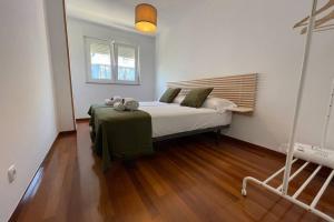 een slaapkamer met een bed en een houten vloer bij Oktheway Calvo Sotelo in Sarria
