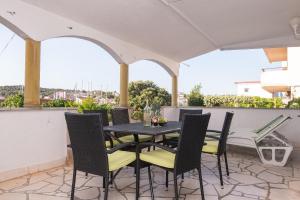 a patio with a table and chairs on a balcony at Apartments Matija - 30m from sea in Jezera