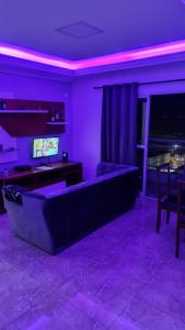Apartamento De Alto Padrão - Ocian في برايا جراندي: غرفة معيشة أرجوانية مع أريكة وطاولة