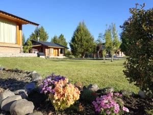 a garden with flowers in front of a house at Masia del Valle in Trevelín +38 photos