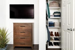 a closet with a tv and a dresser with shoes at InTown Suites Extended Stay Select Houston TX - Stafford in Stafford