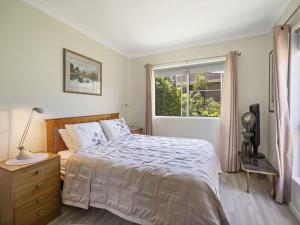 a bedroom with a bed and a window at Dragonfly by Experience Jervis Bay in Vincentia