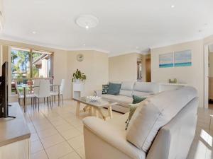 a living room with a couch and a table at Pool in Paradise by Experience Jervis Bay in Vincentia