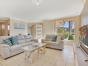 a living room with two couches and a tv at Pool in Paradise by Experience Jervis Bay in Vincentia