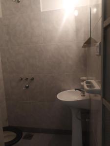 Departamentos Temporarios Salta في سالتا: حمام مع حوض أبيض ومرحاض