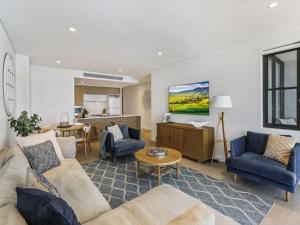 a living room with a couch and a table at 204 on the Beach by Experience Jervis Bay in Huskisson