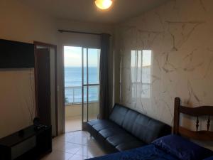 a living room with a couch and a view of the ocean at Apartamento Guarapari Luxo Frente para o Mar in Guarapari