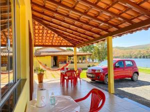 a patio with a table and chairs and a car at Suite independente em casa de fazenda in Capitólio