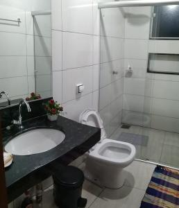 a bathroom with a white toilet and a sink at Suite independente em casa de fazenda in Capitólio